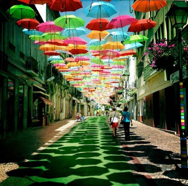  In Águeda, Portugal some streets are decorated with colorful umbrellas protecting walkers from the summer sun.